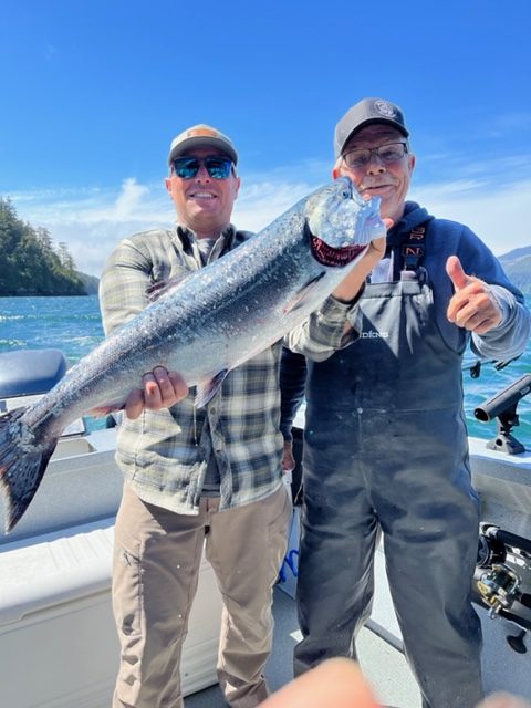 Two fisherman hold up a King Salmon that was caught in Sandspit, B.C.