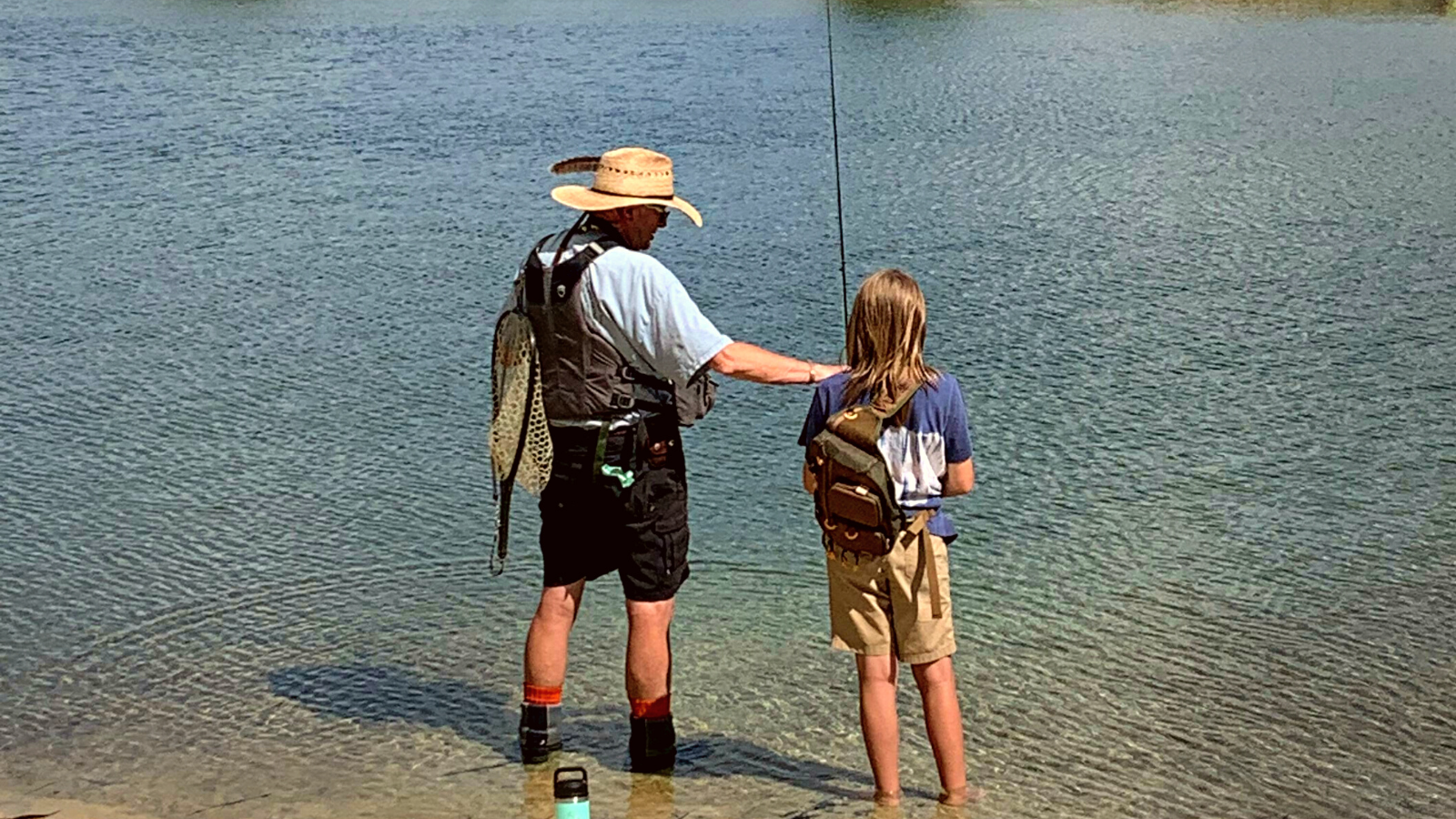 A Mayfly Project mentor teaches a girl about fly fishing.
