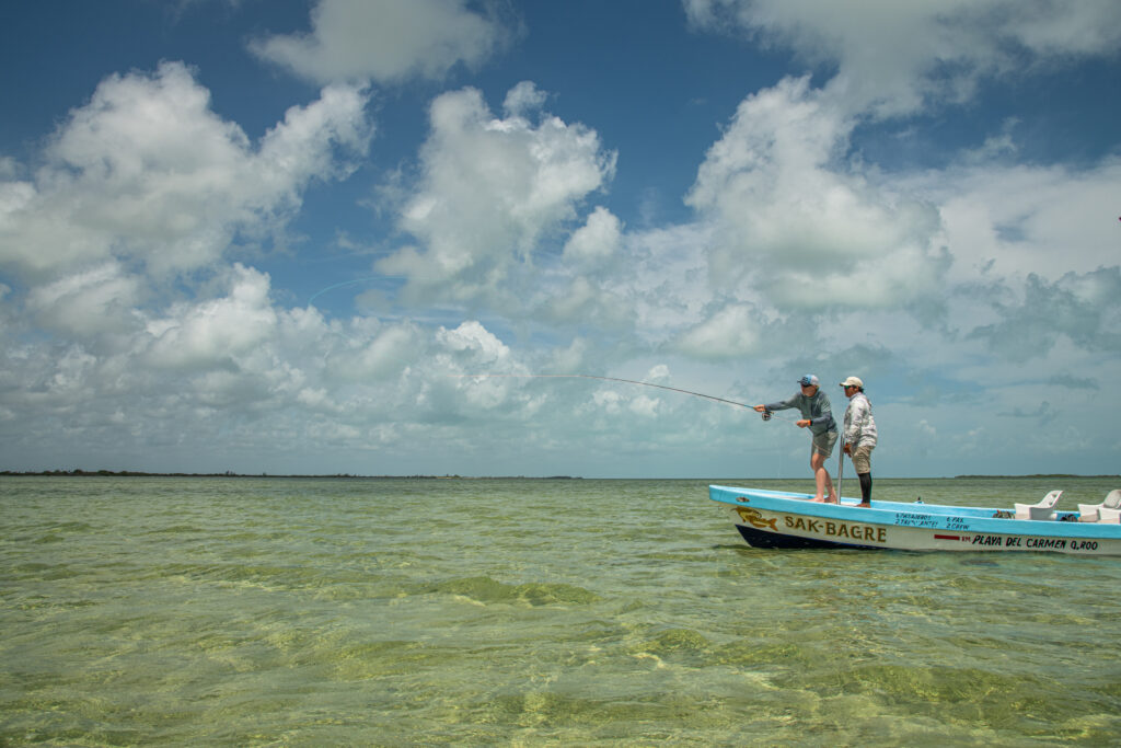 fly fisherman casts off the end of a boat in the Ascension Bay